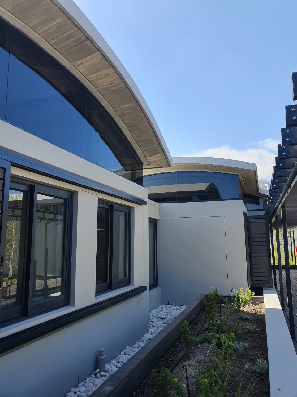 Curved concrete roofing with glass inserts by Hu Art
